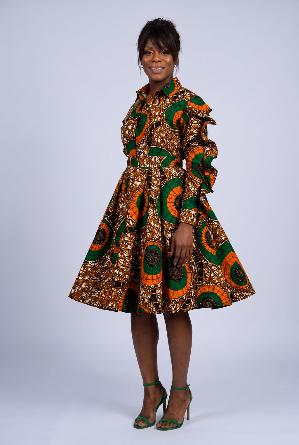 Side turned view of an orange African print shirt dress showing flare skirt movement 