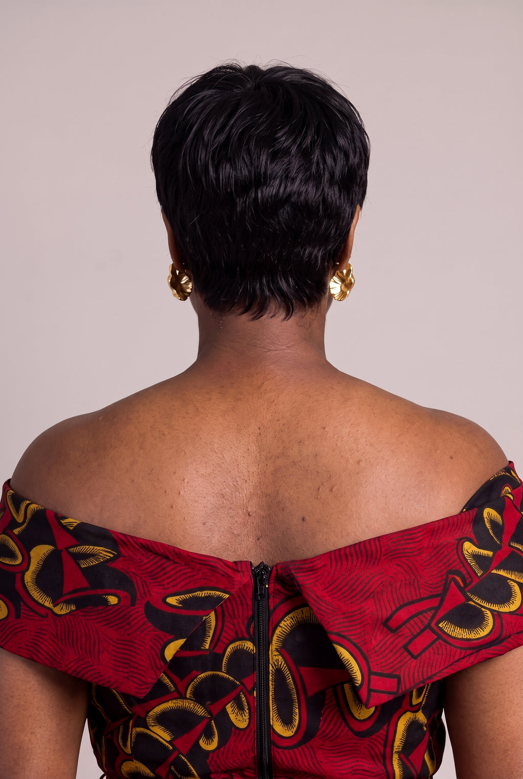 Back view of red African print midi off-shoulder Ankara dress showing folded shoulder band