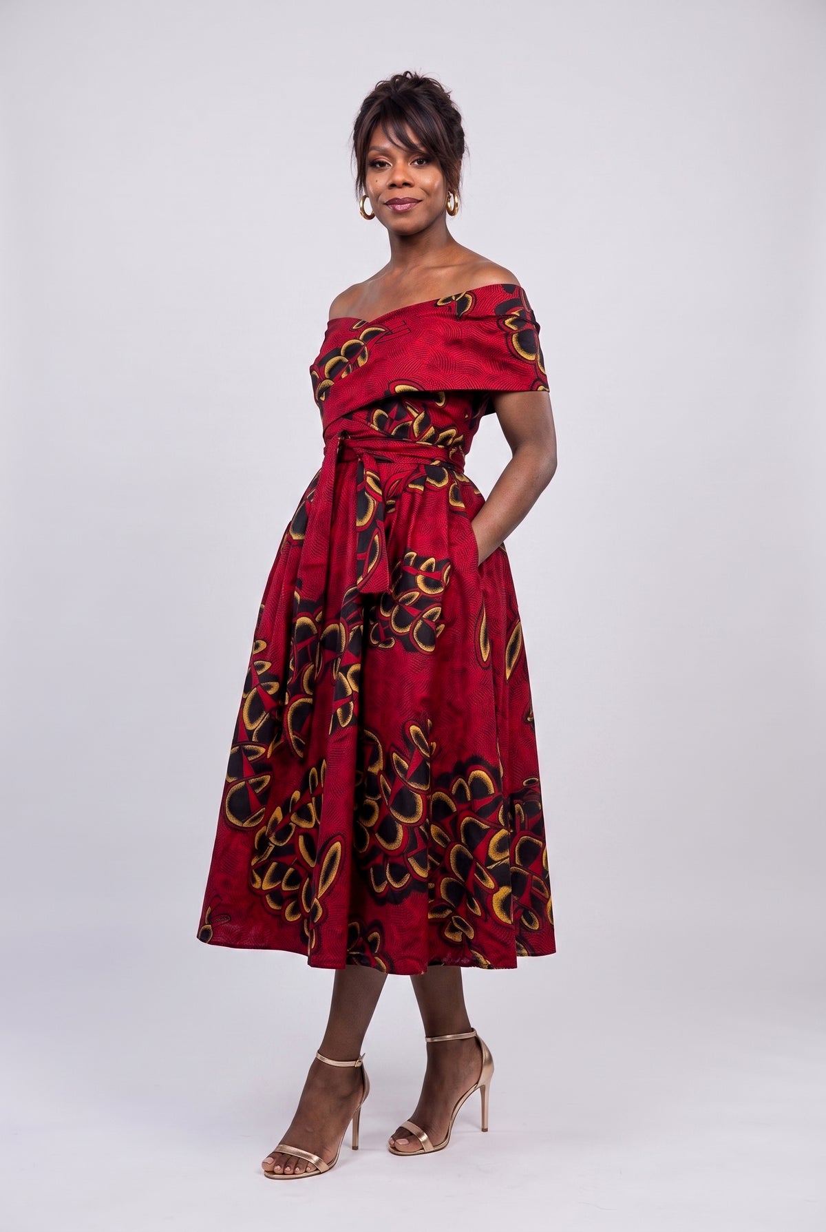Full length side view of red African print dress with full flare skirt 