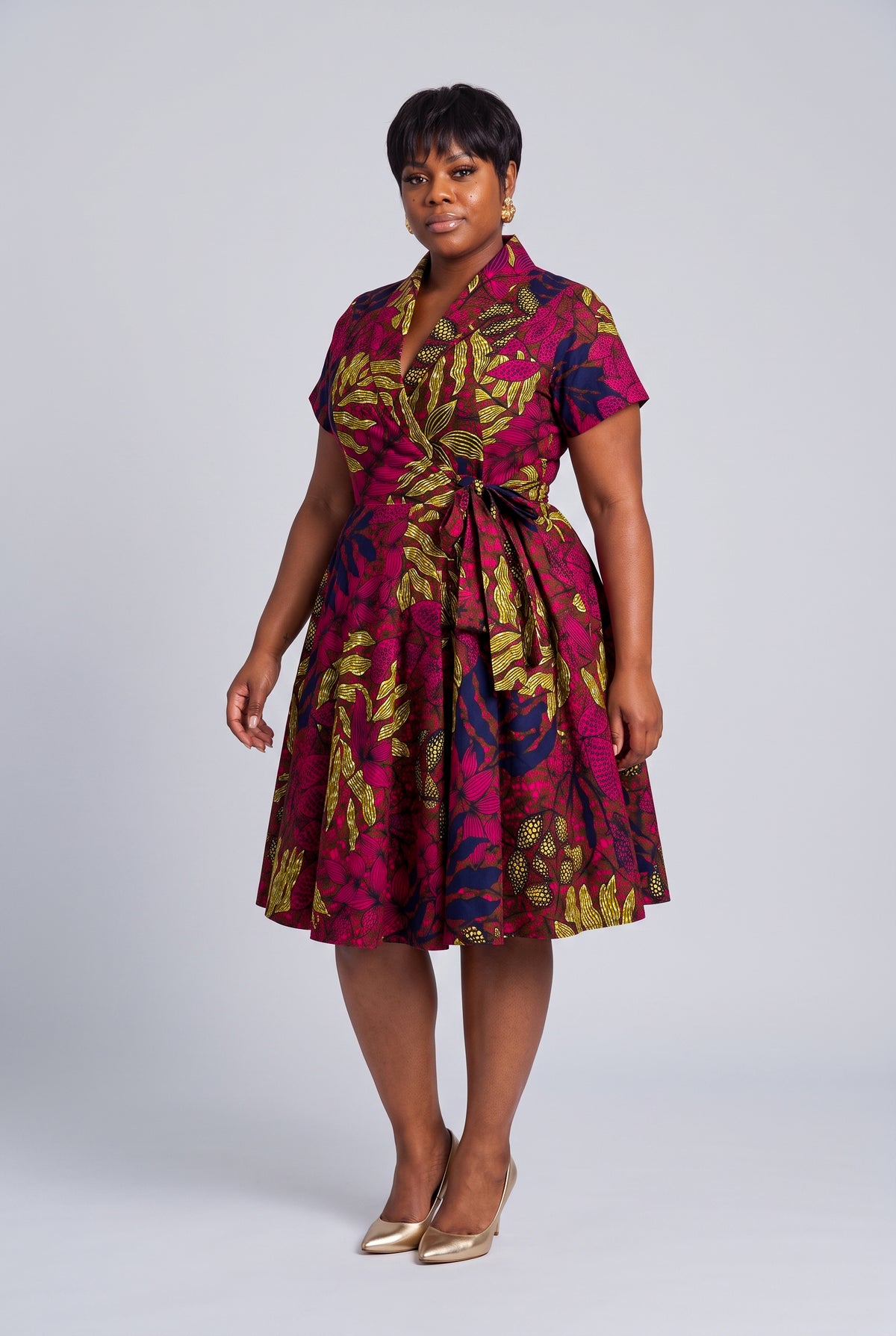 Side view of pink navy and gold Ankara wrap midi dress