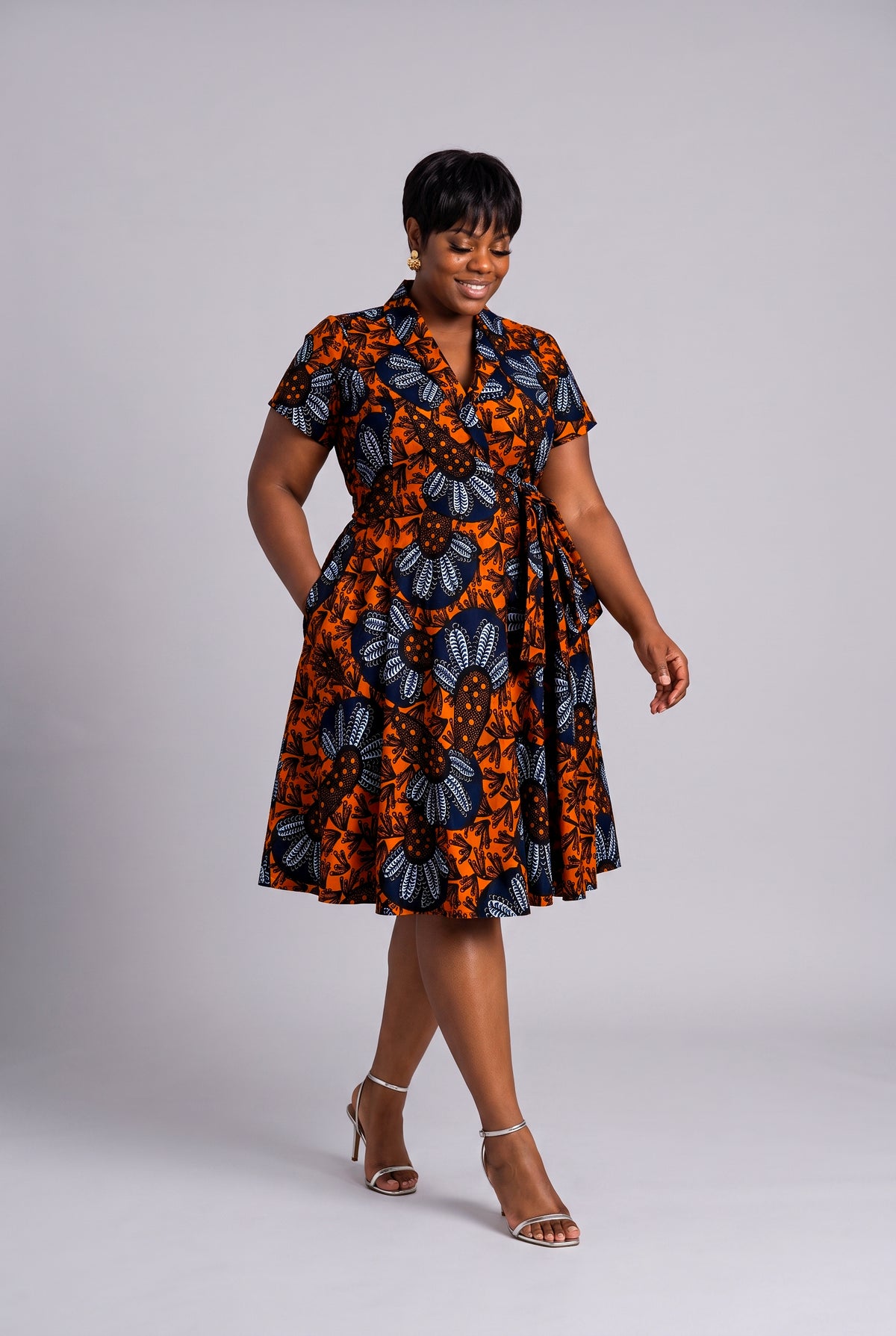 Model walking in fit and flare African print wrap dress 
