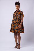 Model wearing Amber Bloom orange African print swing shirt dress with short sleeves and a relaxed fit