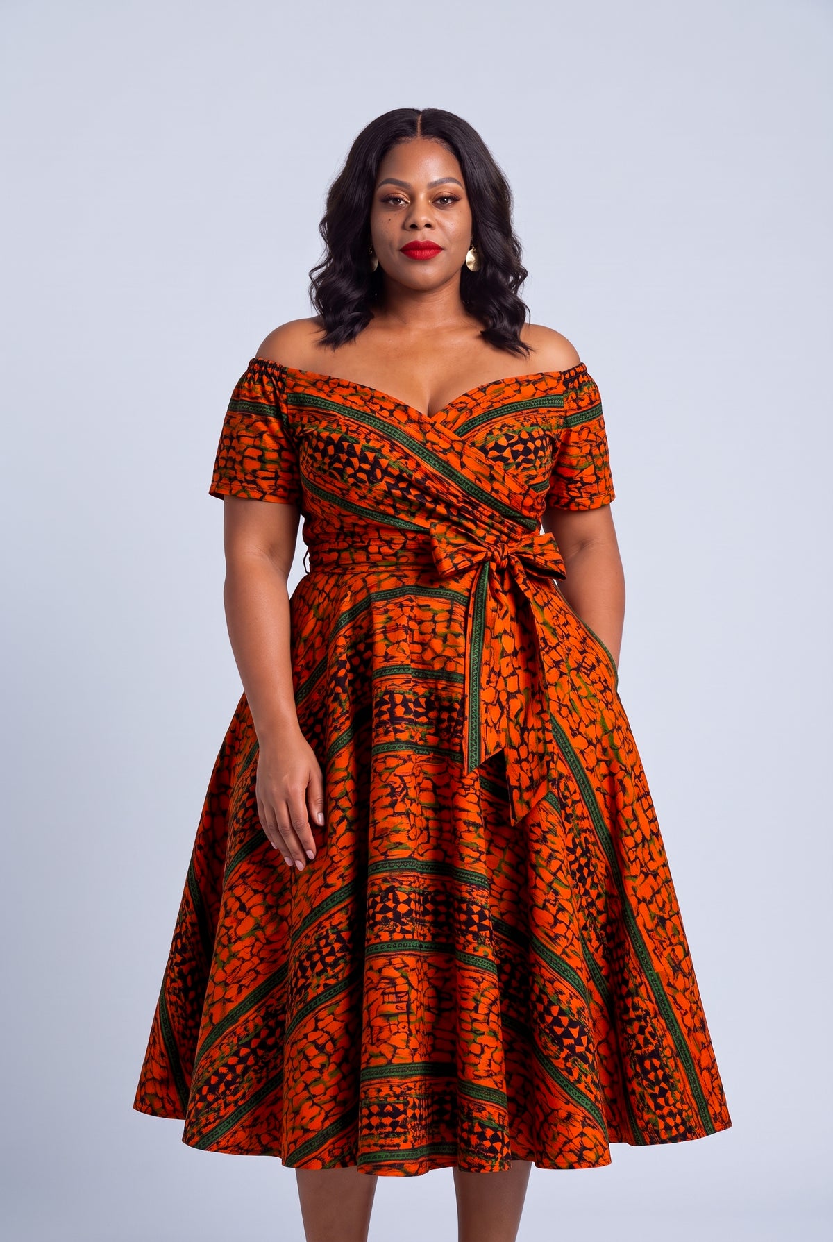 Half length of the orange green and navy Ankara wax print on the Amber Horizon dress