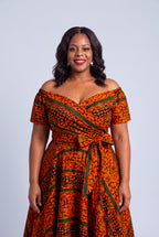 Fitted bodice and full circle flare skirt silhouette on a curve model wearing a  orange Ankara off-shoulder dress
