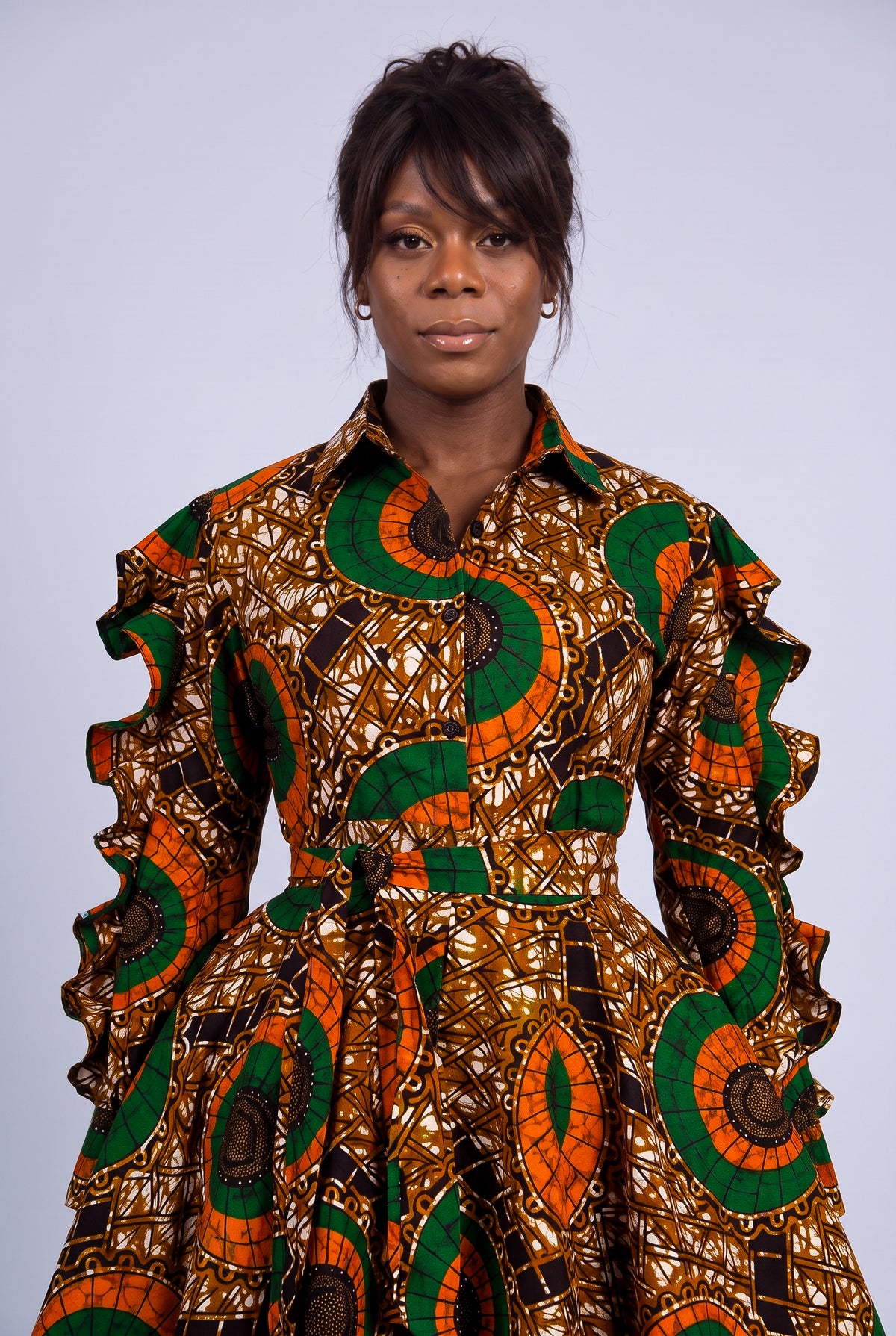 Close-up portrait of a model highlighting the classic point collar and button-through detail of an African wax print dress