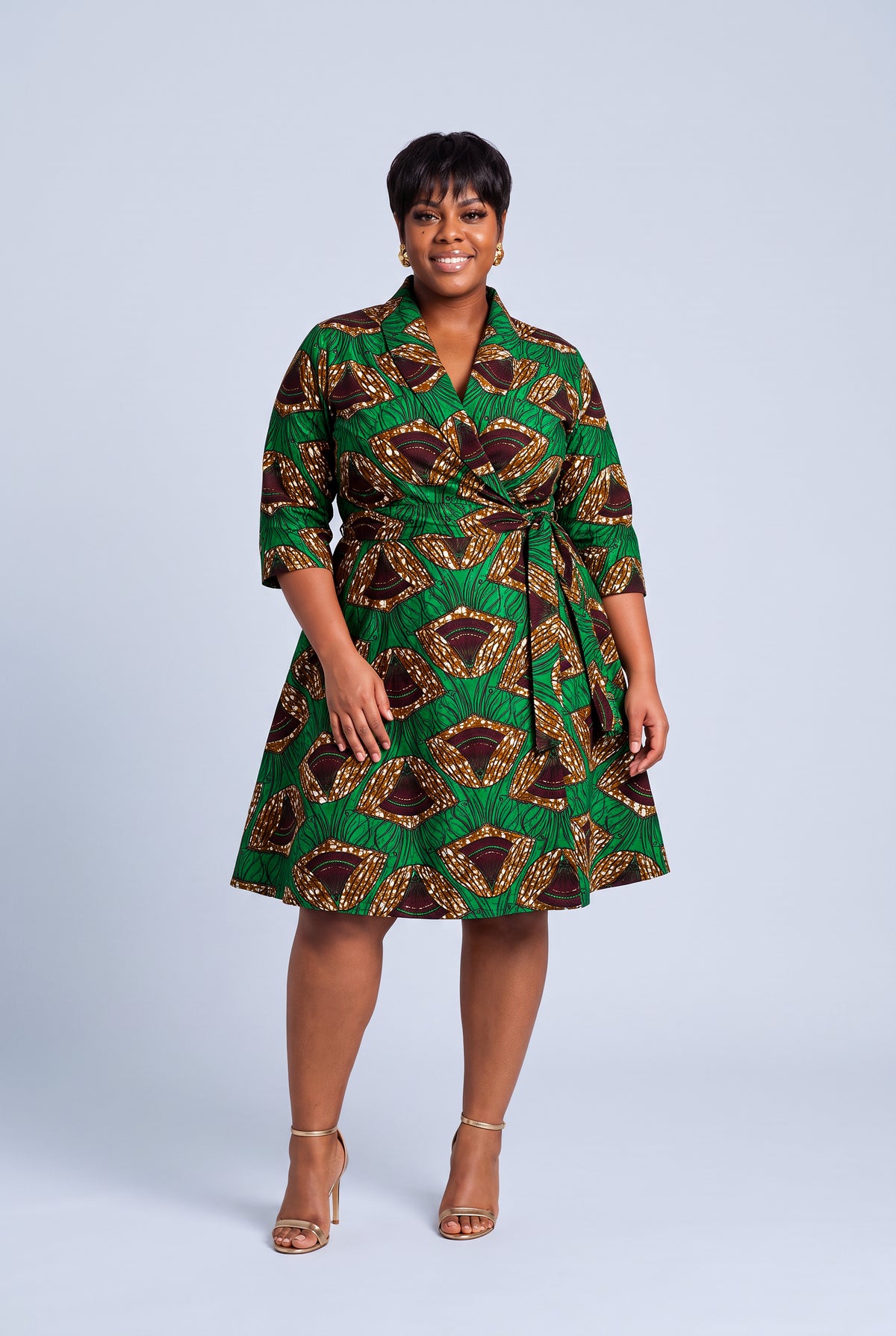 Model wearing Forest Oasis green and brown African print Ankara wrap midi dress with three quarter sleeves