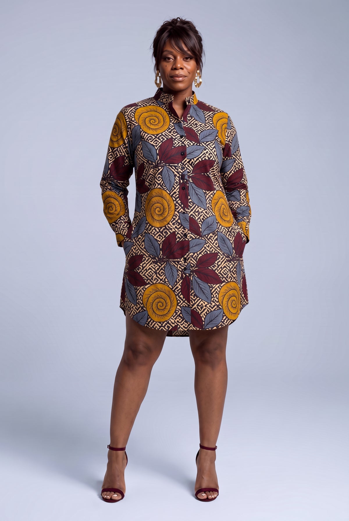 Model wearing Ochre Grove African print shirt dress with hands in the functional pockets