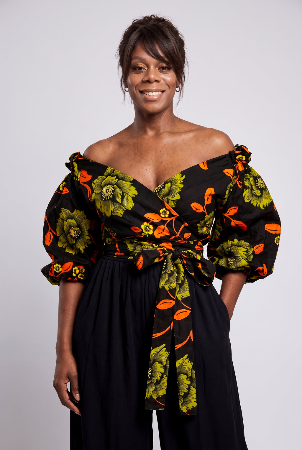 Close up shot of a crossover sweetheart neckline with a subtle ruffle trim on an olive green Ankara blouse