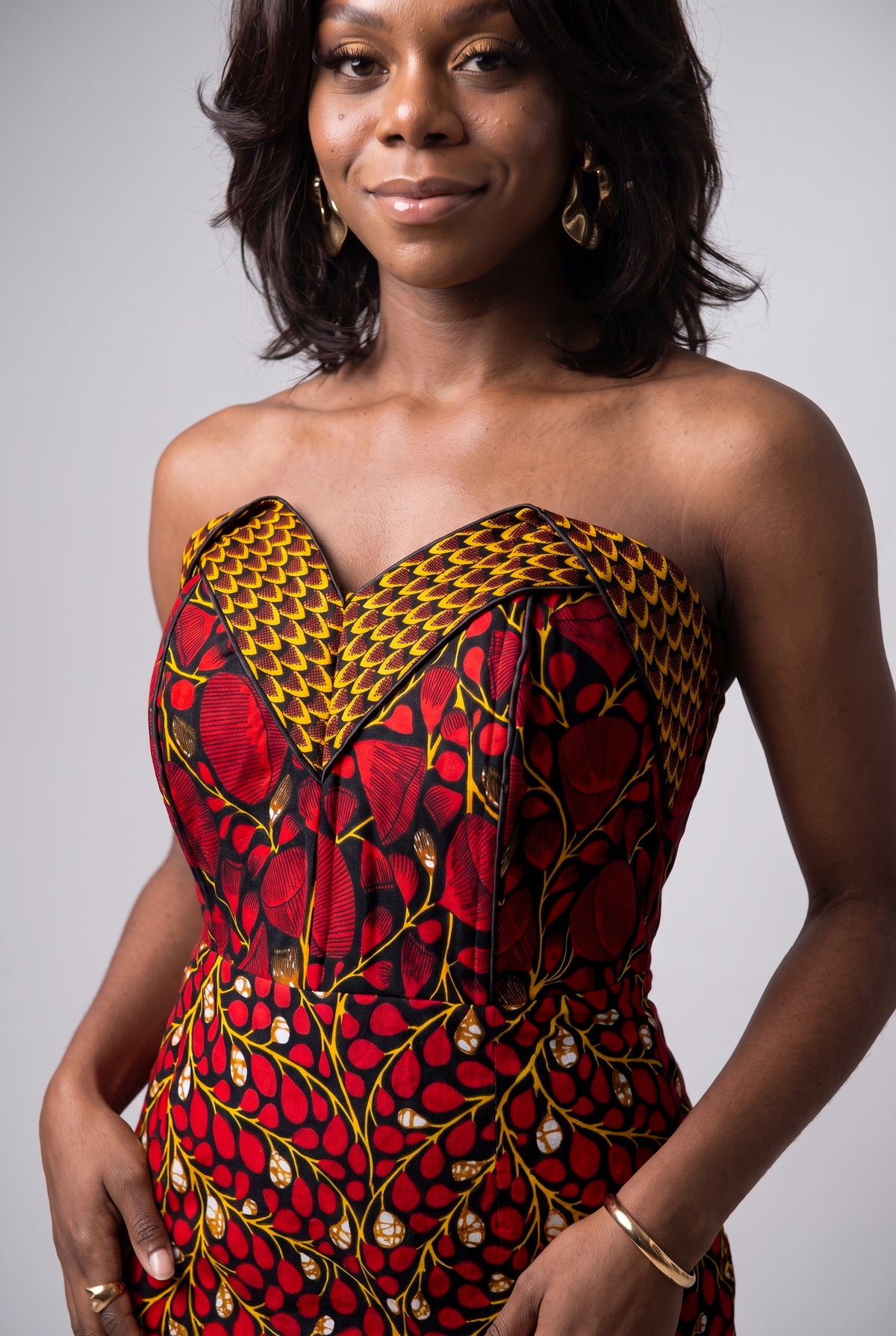 Detailed view of visible corset panel construction and waist shaping on a  red African print dress
