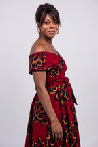 Side profile of red African print off shoulder dress showing shoulder band and waist tie