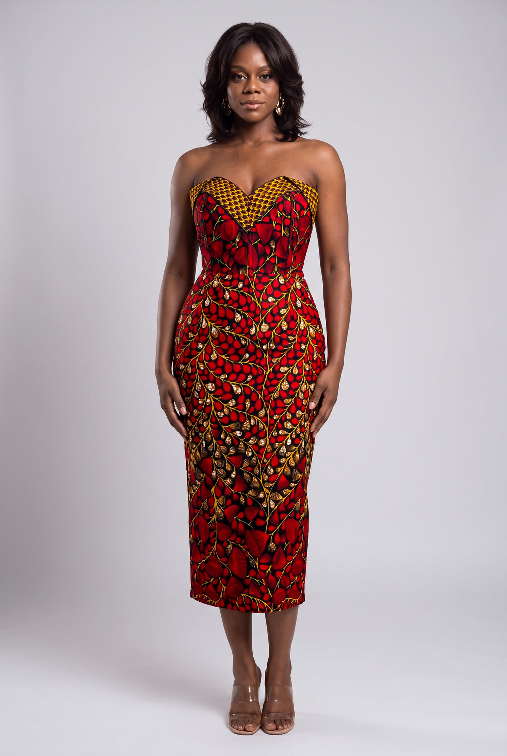 Model wearing  red  African print corset midi dress with strapless sweetheart neckline