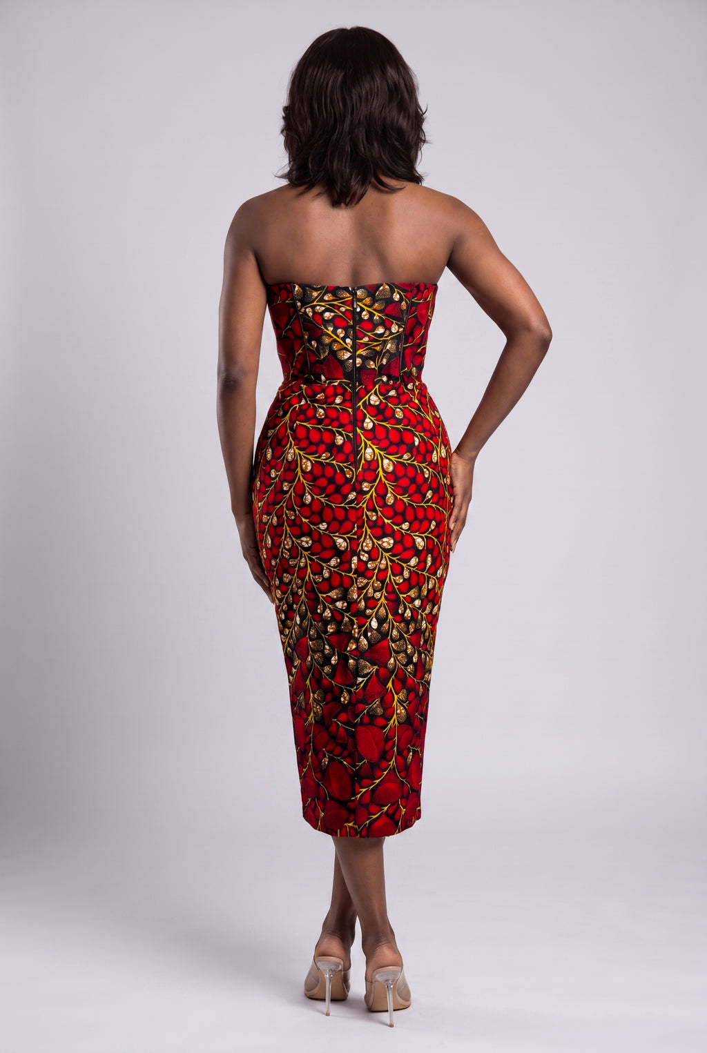 Back view of red African print fitted corset midi dress