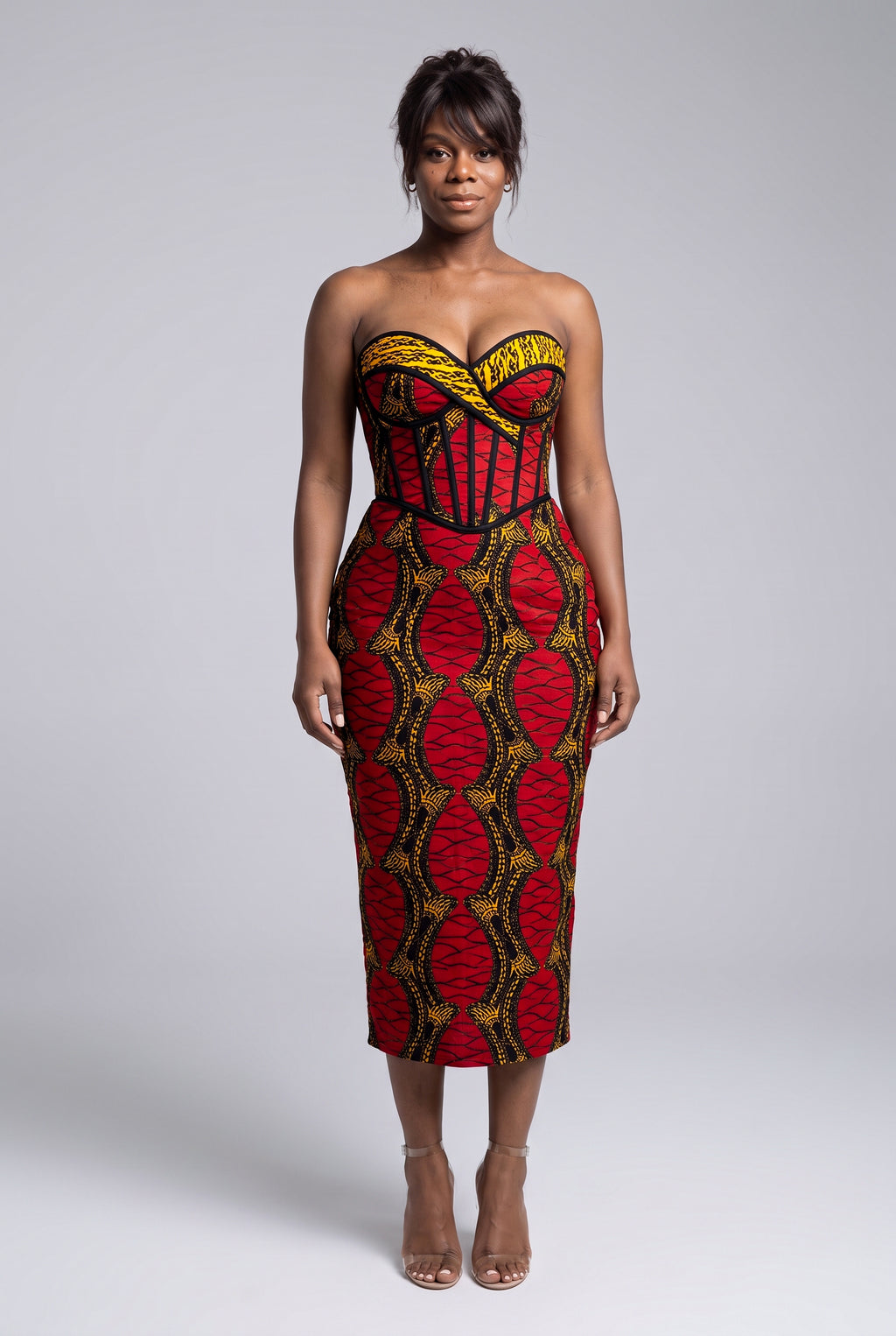Model wearing Red Grid red African print strapless corset midi dress with a fitted silhouette