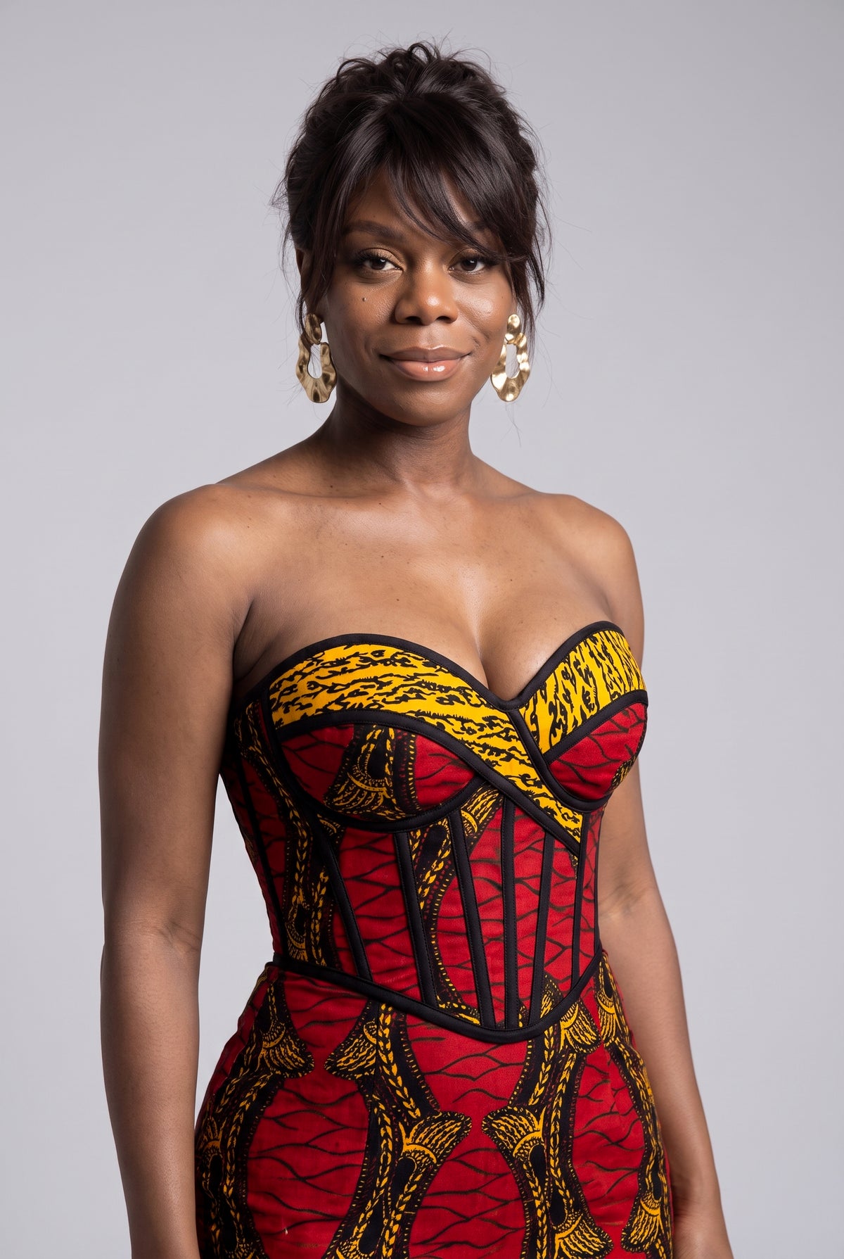 Close up of Red Grid strapless corset bodice in red gold and black African print