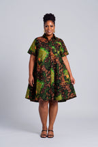 Model wearing Verdant Ripple green African print swing shirt dress with short sleeves and a relaxed flare