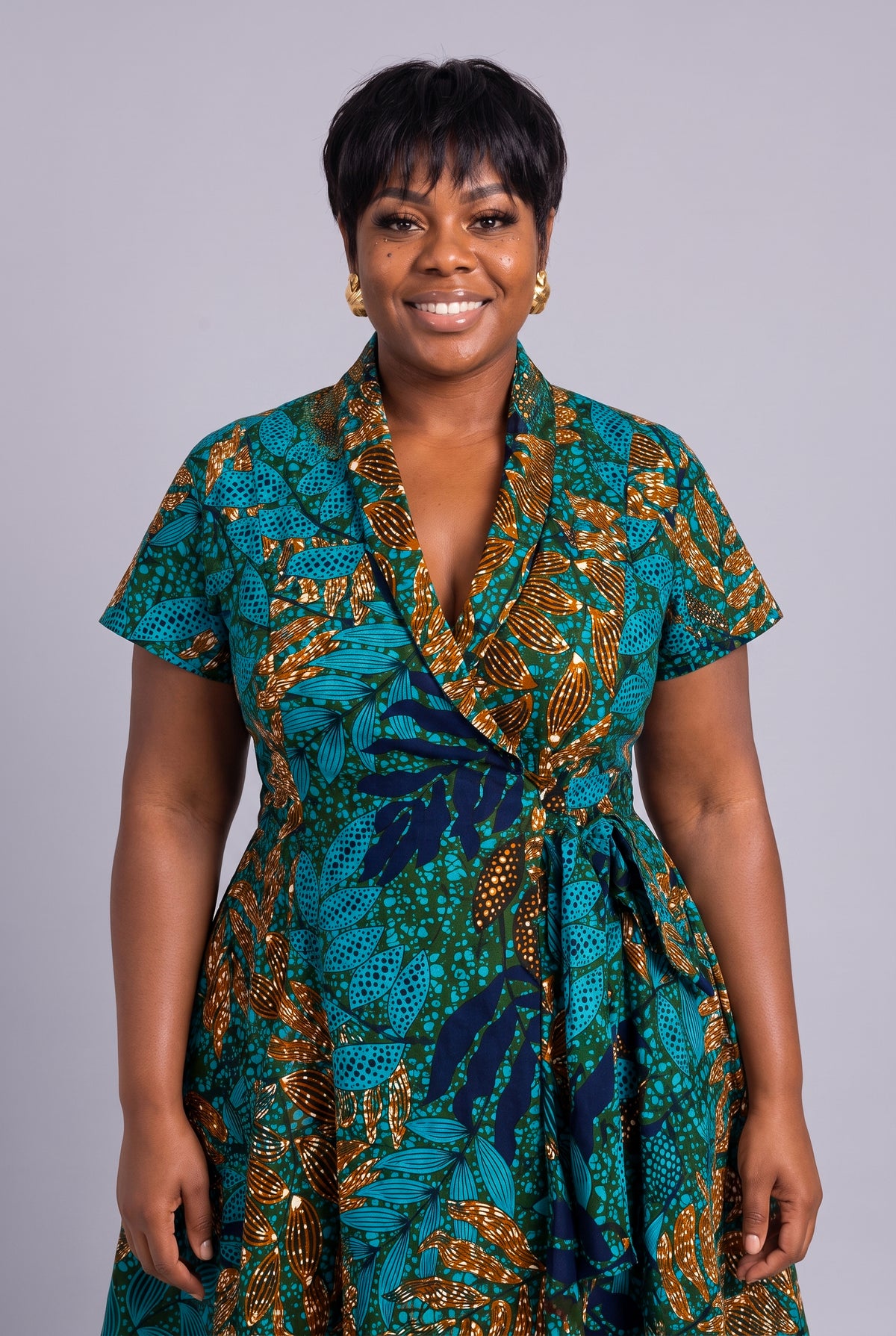Smiling model in African print wrap dress, front view
