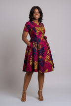 Front view of Pink African wax print wrap dress with hand in pocket