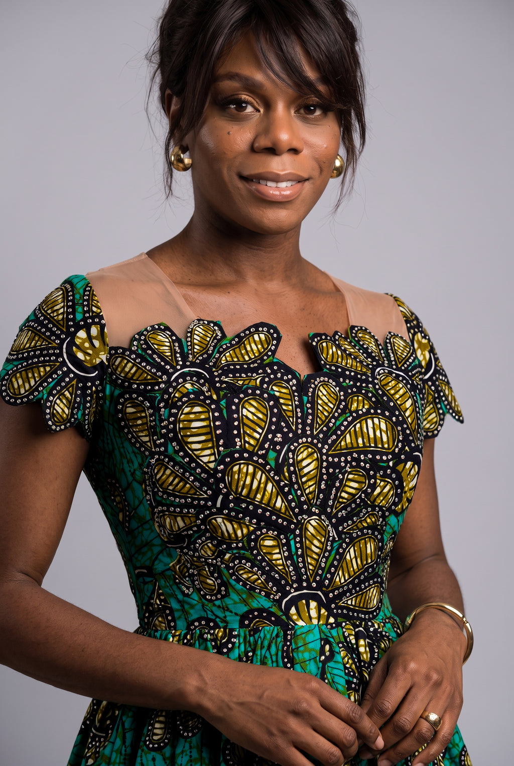  Close up view of the structured fitted bodice on a vibrant green teal and gold Ankara church dress