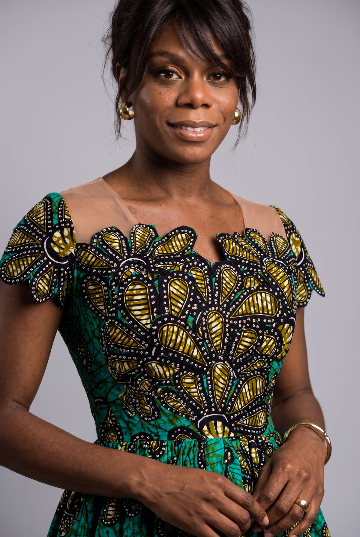  Close up view of the structured fitted bodice on a vibrant green teal and gold Ankara church dress