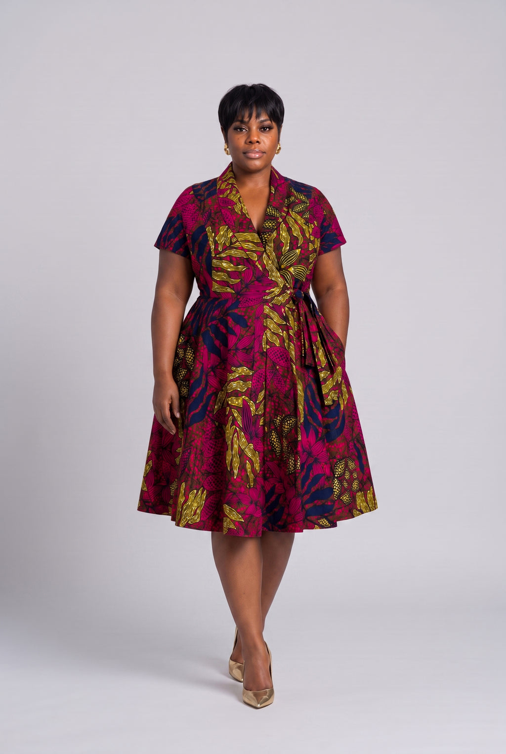 Plus size model wearing Fern Bloom pink Ankara wrap dress
